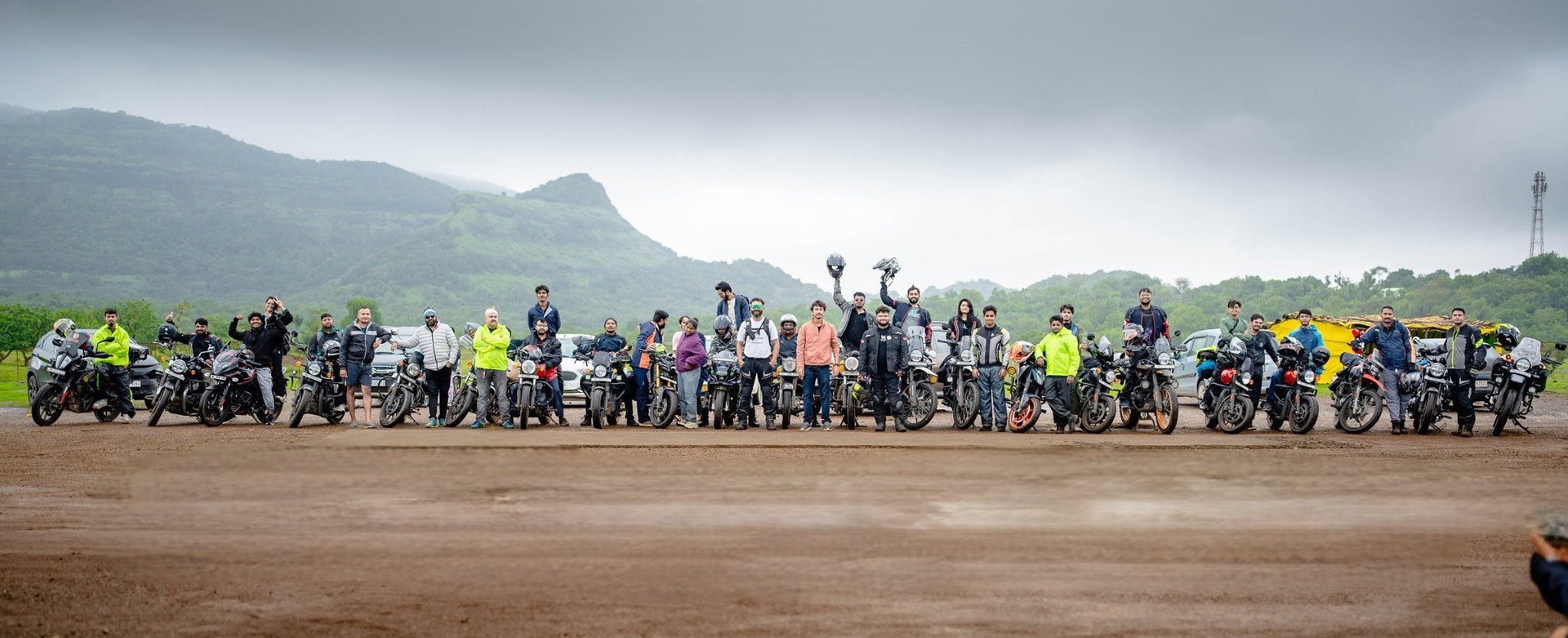 The Rydin riders lined up with their motorcycles in front of the mountains