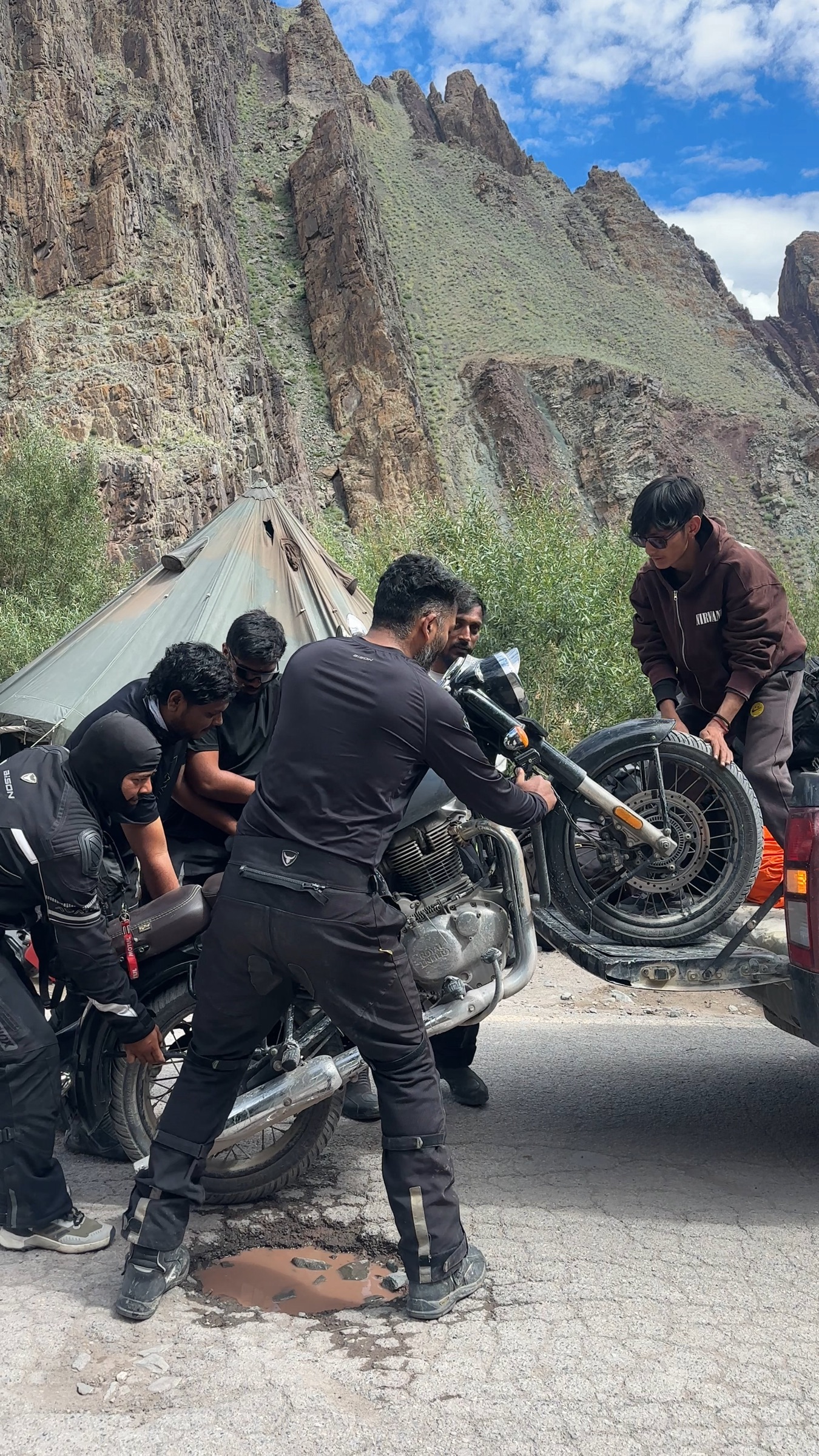 The Rydin riders and a mechanic loading a bike onto the support truck